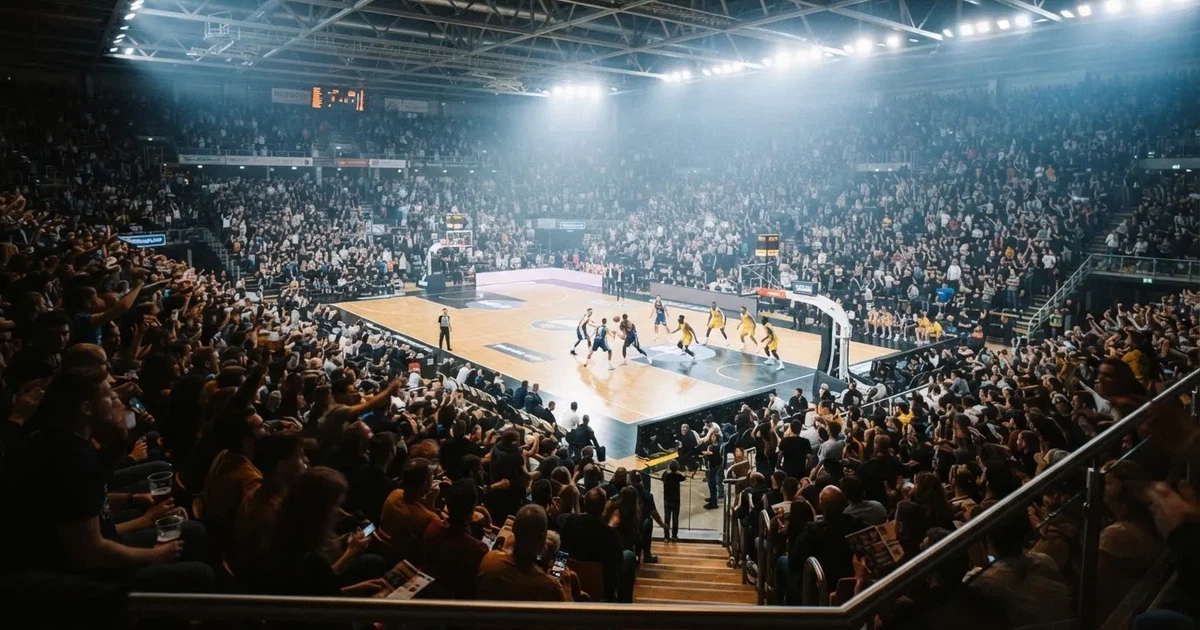 Un pabellón deportivo lleno bajo los focos, fotografiado desde muy lejos