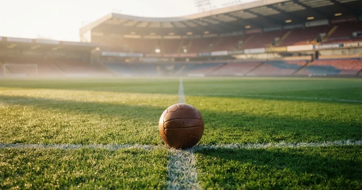 Un balón en el punto central de un campo de césped a la luz de la mañana