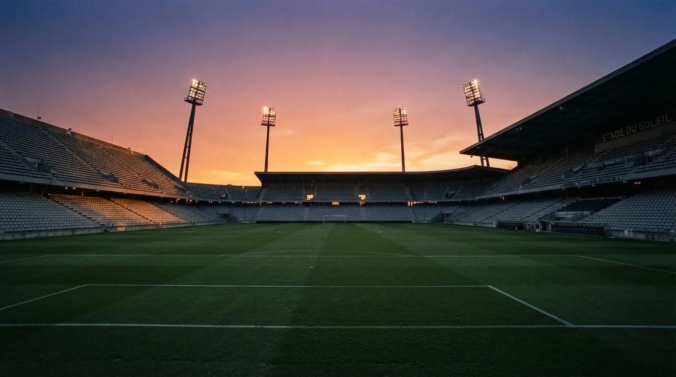 Un estadio de fútbol vacío con torres de iluminación al atardecer